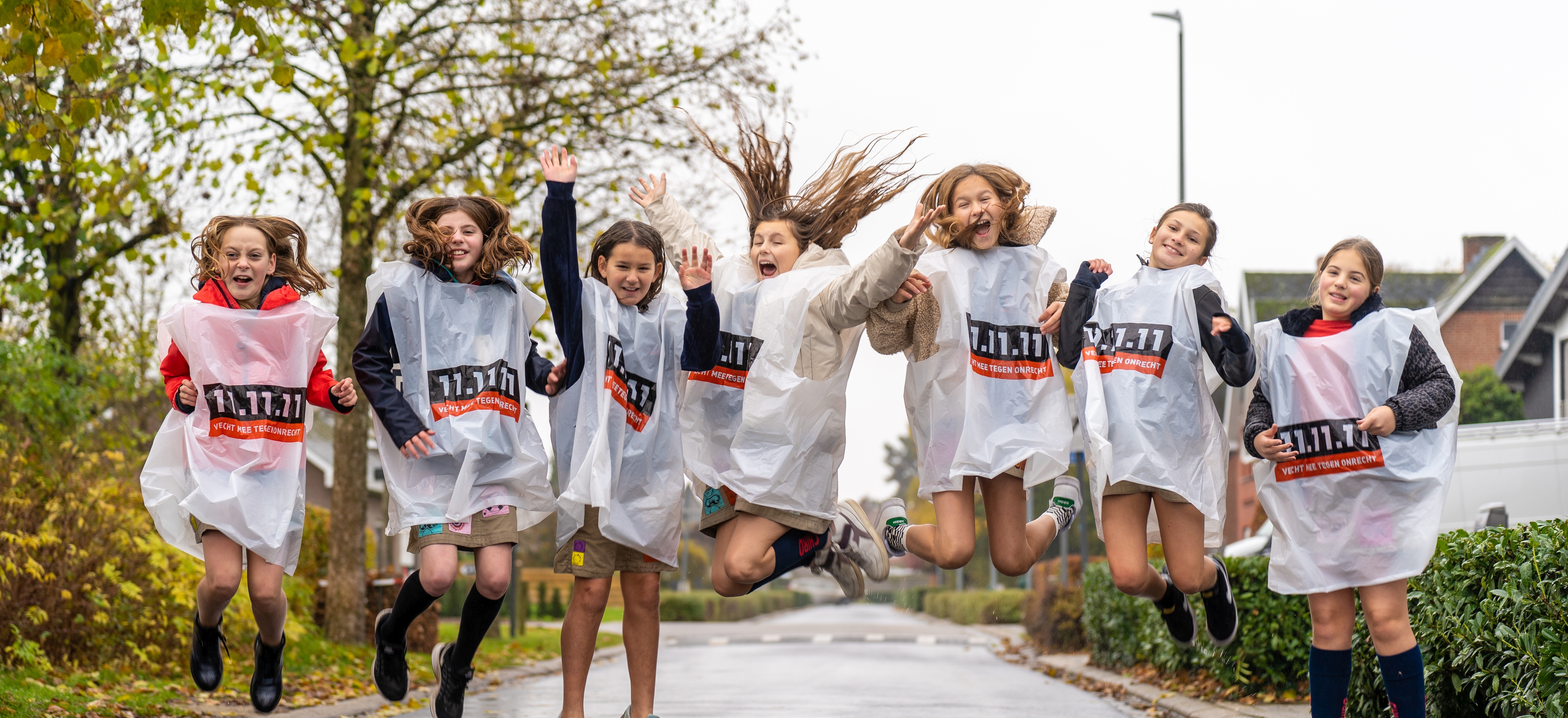 Groep kinderen springt de lucht in in hesjes 11.11.11