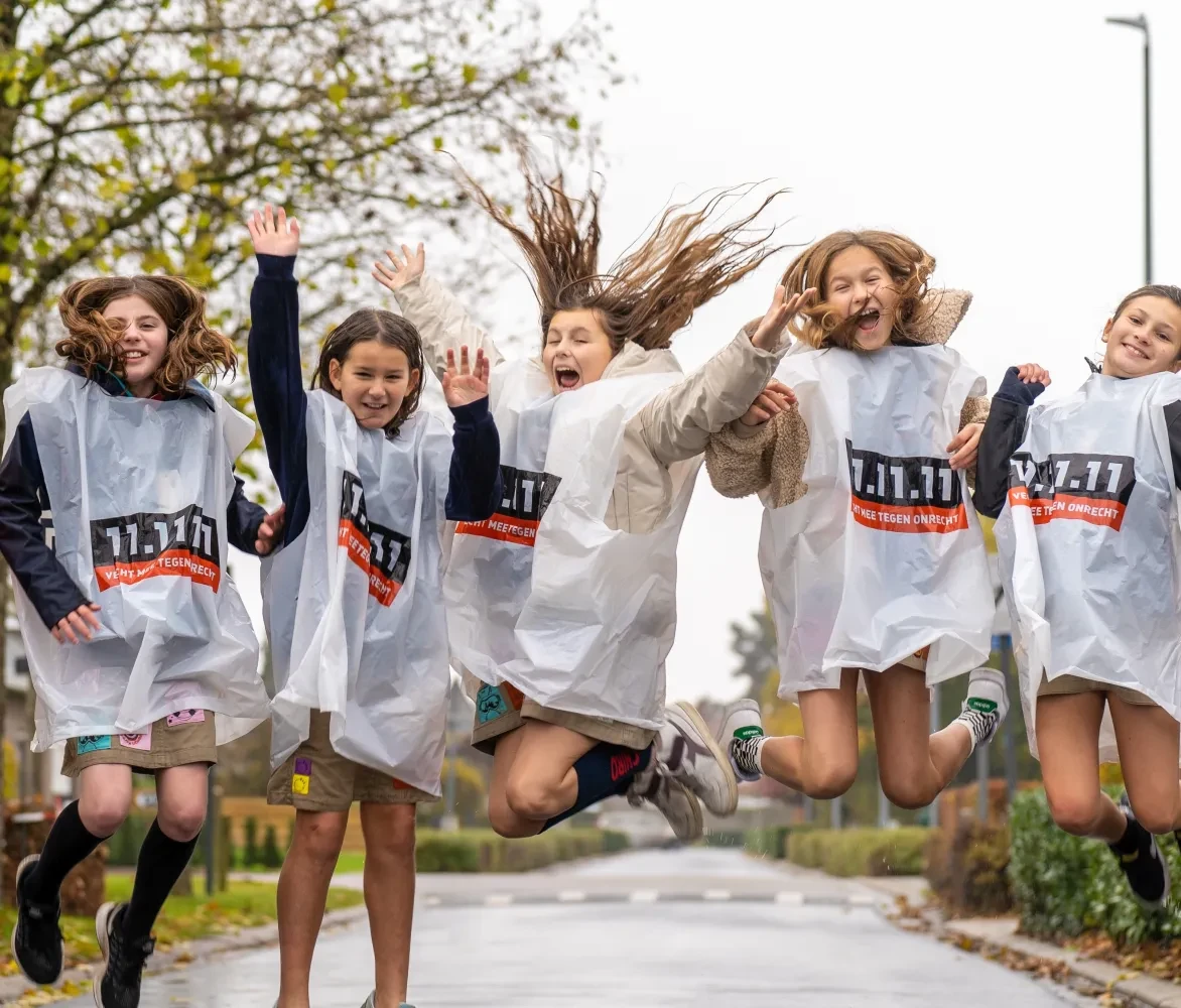 Groep kinderen springt de lucht in in hesjes 11.11.11