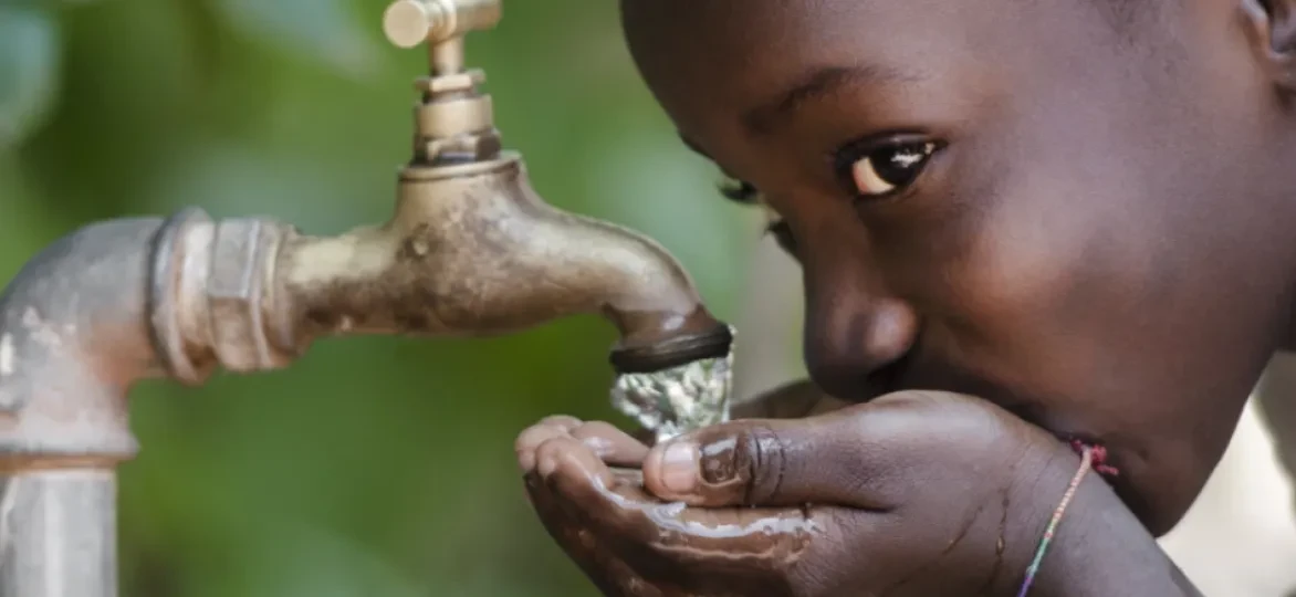 Meisje drinkt van kraan