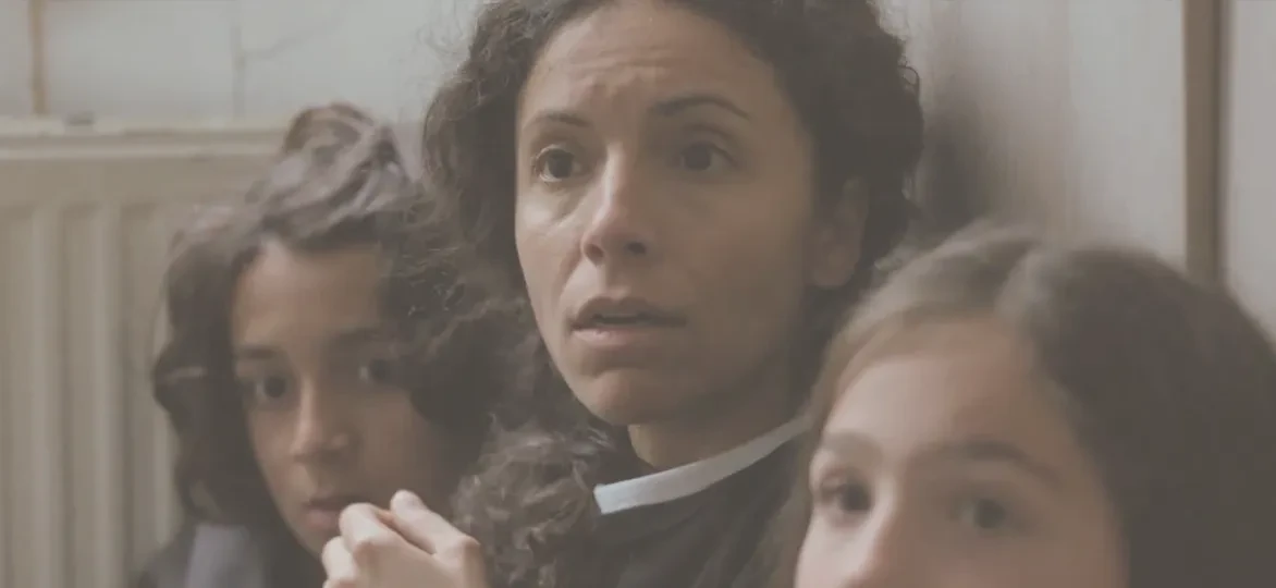 Een moeder met haar kinderen verschuilt zich tijdens de inval van de politie in hun huis