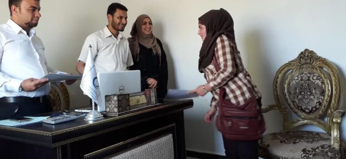 Amina neemt trots haar diploma in ontvangst.