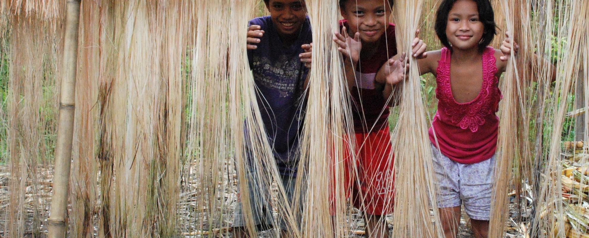 Kinderen spelen met drogende abaca (manila vezels) in de Filipijnen