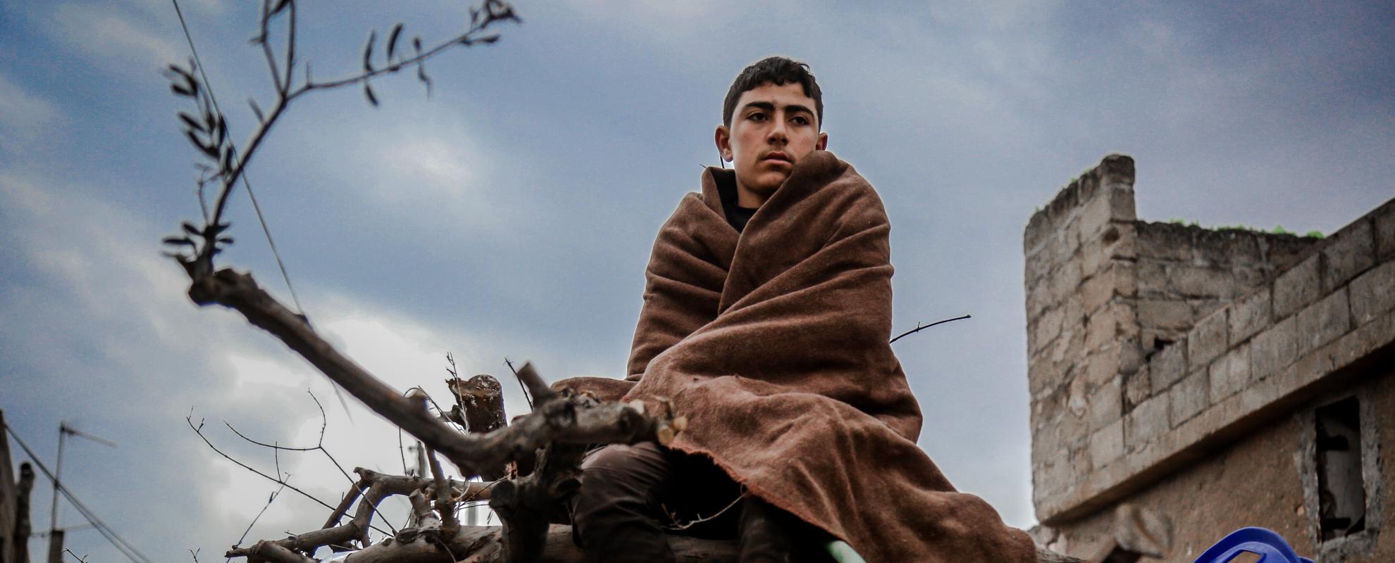 Een jongen zit op het puin in de Syrische stad Kan Shakyun (Foto: Anas Aldyab)
