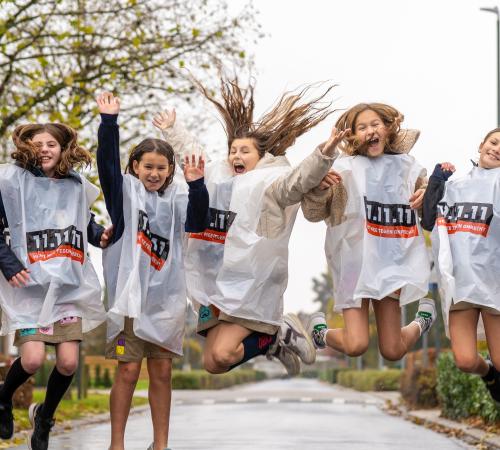 Groep kinderen springt de lucht in in hesjes 11.11.11