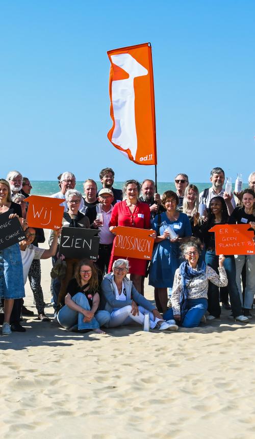 Groepsfoto van alle deelnemers op het strand