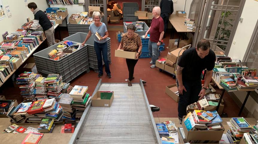 Sorteren van de boeken tijdens de opbouw van de boekenverkoop in Gent