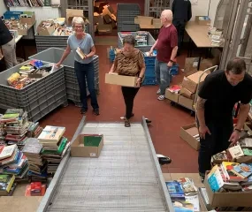 Sorteren van de boeken tijdens de opbouw van de boekenverkoop in Gent
