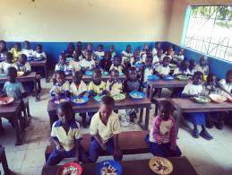 Kinderen krijgen een maaltijd op school in Gambia