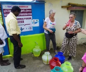 Een bestuurslid proeft het gezuiverde water