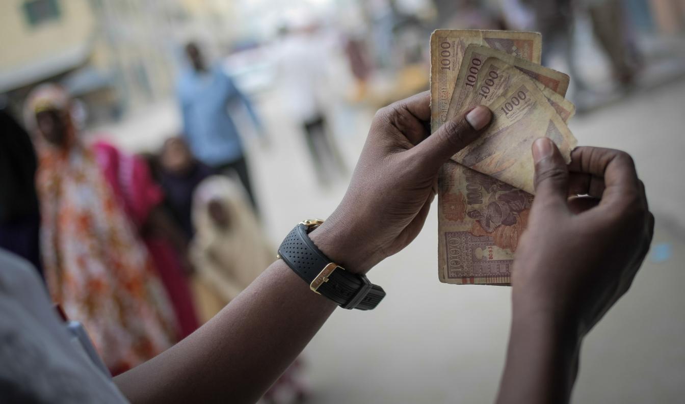 A man counts Somali shilling notes having just exchanged US Dollars