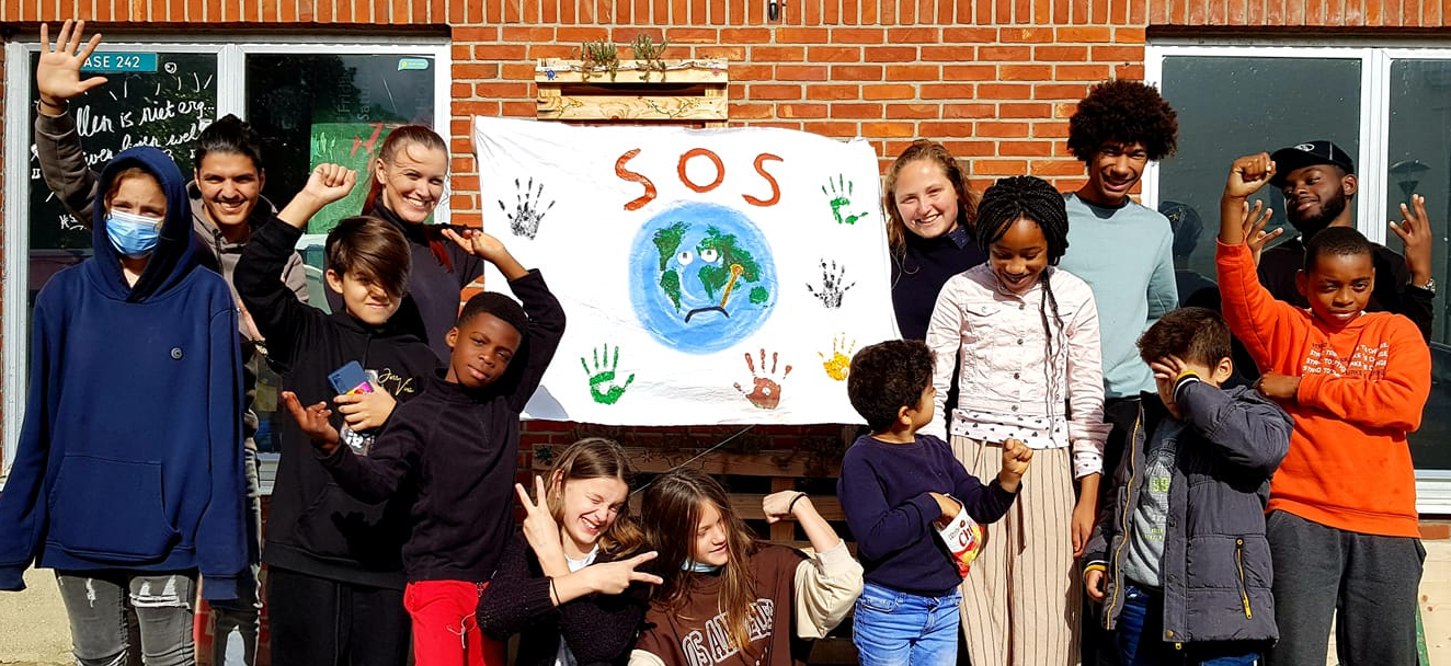 Jongeren van Uit de Marge Leuven met spandoek SOS voor de planeet