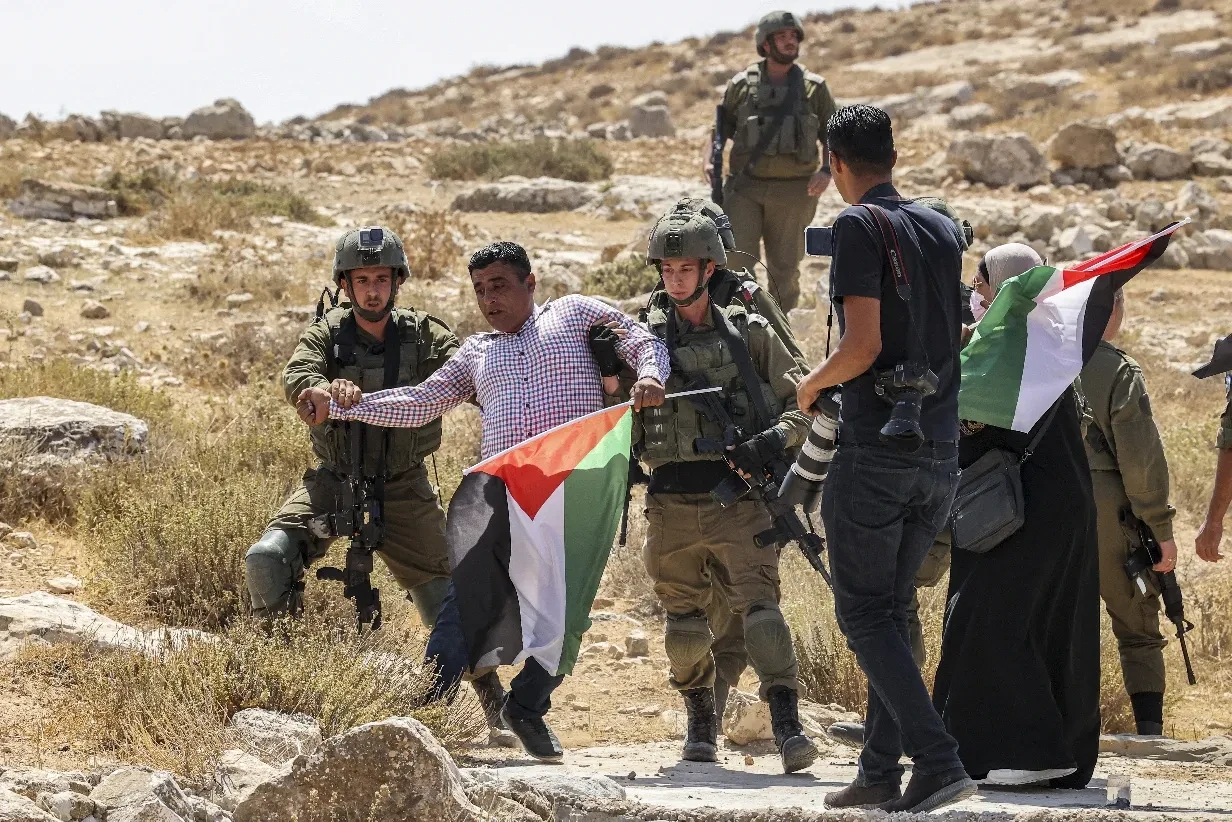 Israëli soldiers arrest a Palestinian demonstrator near Hebron