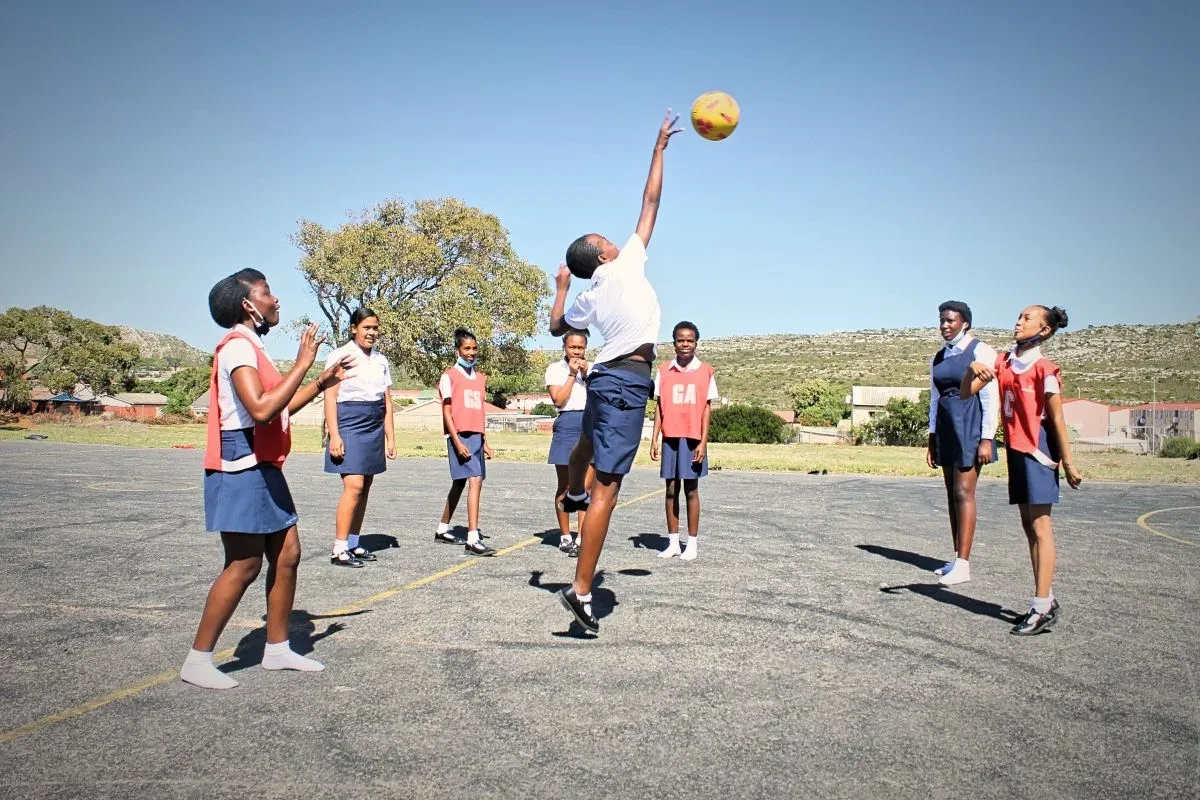 Meisjes spelen korfbal op een project van Boeta