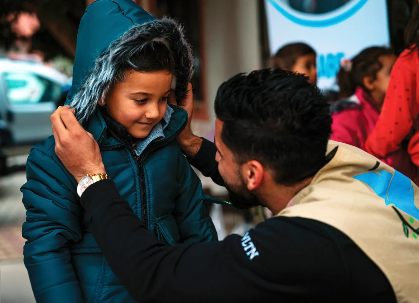 Omar, medewerker van Olive Branch, klaar om de kleine Ahmet te helpen