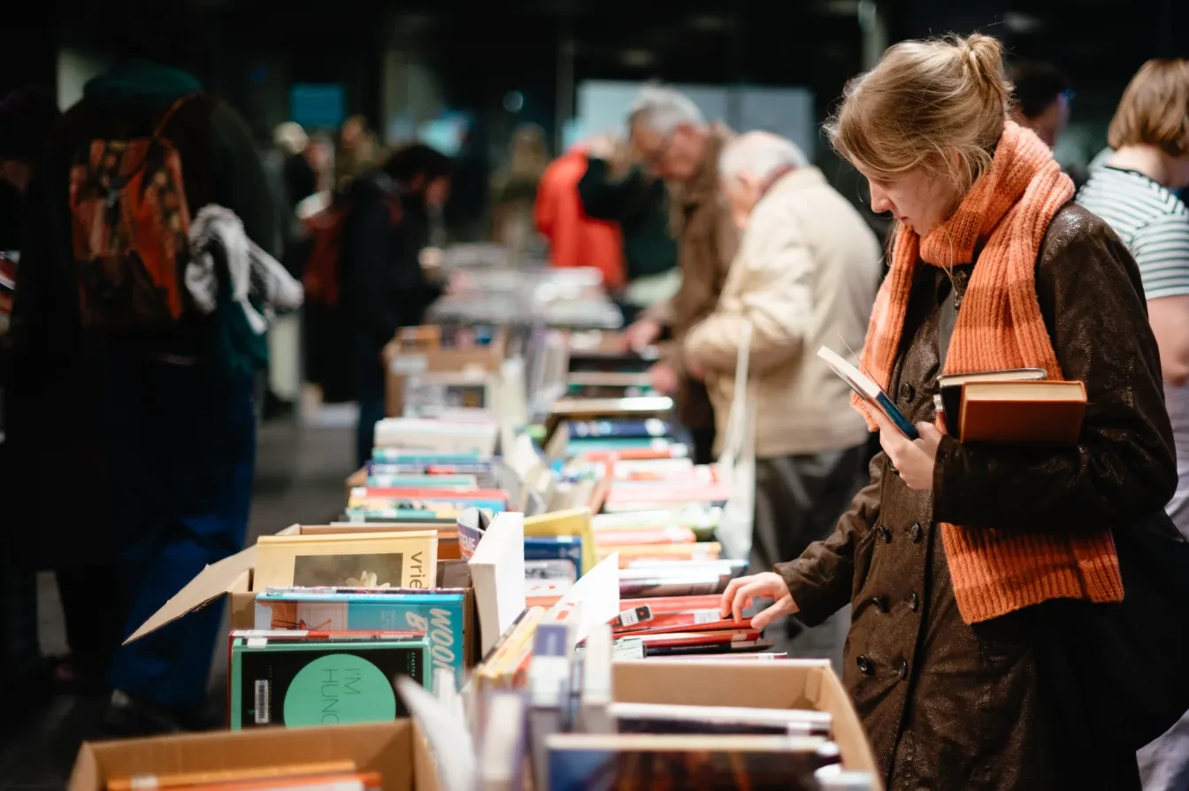 Rij boeken met kopers tijdens de boekenverkoop in Gent