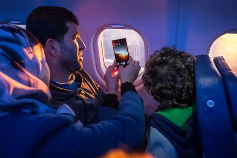 Passagiers nemen een foto door het vliegtuigraampje © IOM/Muse Mohammed 2015