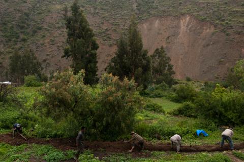 Gemeenschap die gezamelijk werkt aan het graven van een irrigatiekanaal. Op de achtergrond zijn de invloeden van de klimaatsveranderingen duidelijk zichtbaar: meer regenval op korte periode zorgt voor landerosie.