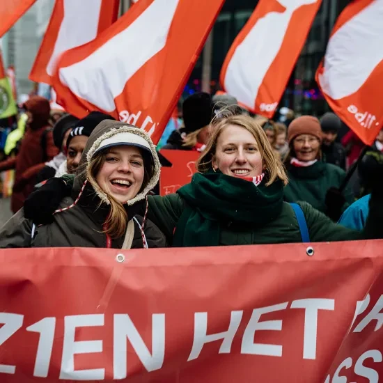 Groep mensen met 11.11.11 vlaggen tijdens de klimaatmars van december 2023